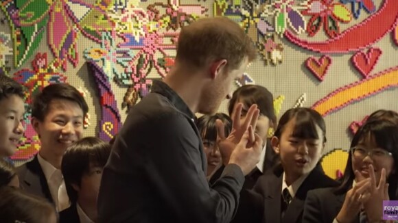 Le prince Harry montre fièrement son alliance à des écolières le 2 novembre 2019 lors d'une rencontre avec des athlètes handisports à Tokyo au Japon.