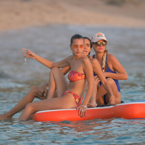 Bella Hadid, Devon Lee Carlson, Laeticia Hallyday - Laeticia Hallyday rejoint Bella Hadid et son équipe de shooting sur un paddle géant et se baigne sur une plage de Saint-Barthélemy le 7 décembre 2019.