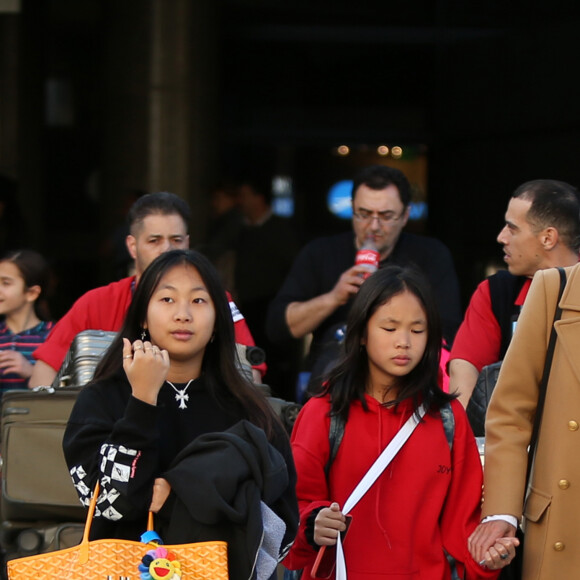 Exclusif - Prix Spécial - No web - No blog - Laeticia Hallyday et ses filles Jade et Joy arrivent à l'aéroport LAX de Los Angeles en provenance de Paris, le samedi 11 janvier 2020 dans l'après-midi. Un chauffeur les attendait à leur arrivée. Laeticia lui fait signe, le salue, puis le suit en compagnie de ses filles jusqu'à la voiture. Deux porteurs poussent ses bagages.  No web/No blog pour Belgique/Suisse11/01/2020 - Los Angeles