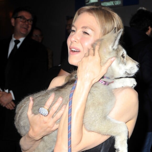 Renée Zellweger prend un chiot dans ses bras à la sortie de l'avant-première du film "Judy" au cinéma Gaumont Marignan à Paris, le 4 février 2020.