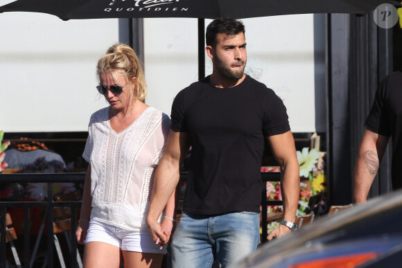 Exclusif - Britney Spears et son compagnon Sam Asghari sont allés déjeuner dans le restaurant 'Le Pain Quotidien' à Beverly Hills. Britney porte une blouse blanche transparente qui laisse entrevoir ses tétons. Le couple semble très amoureux, ils se tiennent la main alors qu'ils traversent la rue, le 12 juillet 2019.