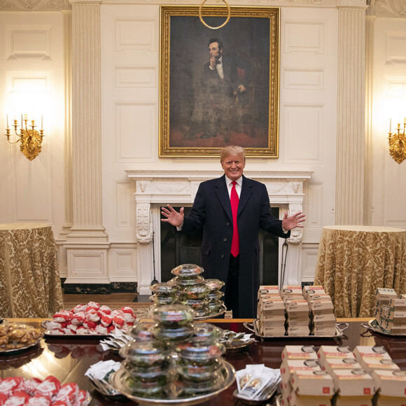 En plein shutdown et faute de cuisiniers à la Maison Blanche Donald Trump a commandé des pizzas et des hamburgers des chaînes de fast-food, pour recevoir les joueurs victorieux de l'équipe de football des Clemson Tigers, vainqueurs du championnat national de football universitaire le 14 janvier 2019.