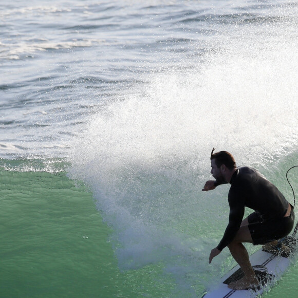 Exclusif - Chris Hemsworth fait du surf avec les dauphins à Byron Bay, en Australie. Le 22 mars 2020.