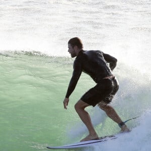 Exclusif - Chris Hemsworth fait du surf avec les dauphins à Byron Bay, en Australie. Le 22 mars 2020.