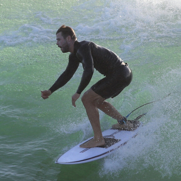 Exclusif - Chris Hemsworth fait du surf avec les dauphins à Byron Bay, en Australie. Le 22 mars 2020.