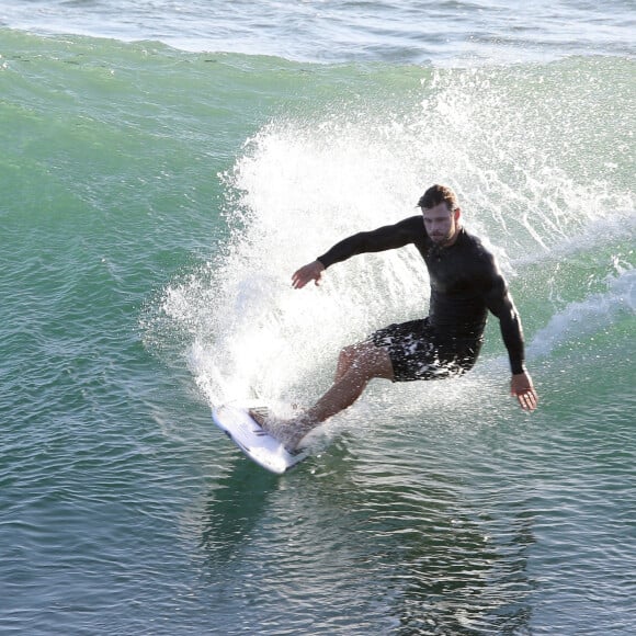 Exclusif - Chris Hemsworth fait du surf avec les dauphins à Byron Bay, en Australie. Le 22 mars 2020.
