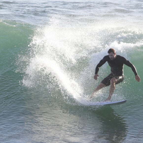 Exclusif - Chris Hemsworth fait du surf avec les dauphins à Byron Bay, en Australie. Le 22 mars 2020.