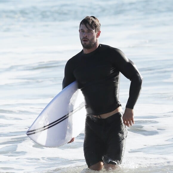 Exclusif - Chris Hemsworth fait du surf avec les dauphins à Byron Bay, en Australie. Le 22 mars 2020.