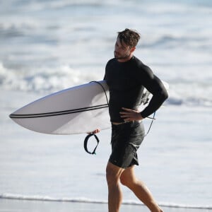 Exclusif - Chris Hemsworth fait du surf avec les dauphins à Byron Bay, en Australie. Le 22 mars 2020.