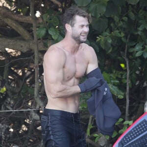 Exclusif - Chris Hemsworth fait du surf avec les dauphins à Byron Bay, en Australie. Le 22 mars 2020.