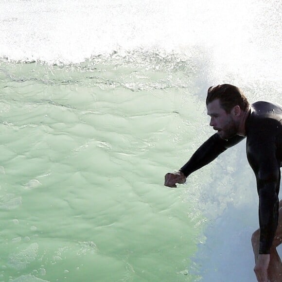 Exclusif - Chris Hemsworth fait du surf avec les dauphins à Byron Bay, en Australie. Le 22 mars 2020.