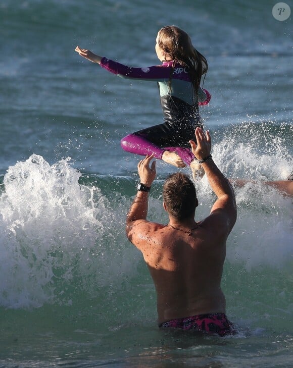 Exclusif - Luke Hemsworth ("Westworld"), le grand frère de Chris et Liam Hemsworth, profite des joies de la plage avec sa fille à Byron Bay en la faisant sauter dans les vagues, le 22 mars 2020.