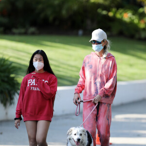 Laeticia Hallyday, ses filles Jade et Joy, Christina, avec des masques, et leurs chiens Santos, Cheyenne et Bono se promènent dans le quartier de Pacific Palisades, à Los Angeles, Californie, Etats-Unis, le 3 avril 2020, pendant la période de confinement.