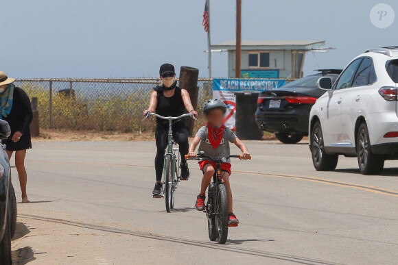 Exclusif - Reese Witherspoon et son mari Jim Toth, munis de masques de protection contre le coronavirus (Covid-19), se promènent à vélo avec leur fils de 7 ans, Tennessee, en bord de mer. Malibu, le 31 mai 2020.