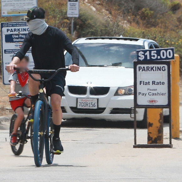 Exclusif - Reese Witherspoon et son mari Jim Toth, munis de masques de protection contre le coronavirus (Covid-19), se promènent à vélo avec leur fils de 7 ans, Tennessee, en bord de mer. Malibu, le 31 mai 2020.