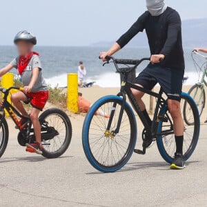 Exclusif - Reese Witherspoon et son mari Jim Toth, munis de masques de protection contre le coronavirus (Covid-19), se promènent à vélo avec leur fils de 7 ans, Tennessee, en bord de mer. Malibu, le 31 mai 2020.