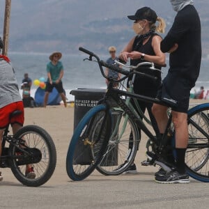 Exclusif - Reese Witherspoon et son mari Jim Toth, munis de masques de protection contre le coronavirus (Covid-19), se promènent à vélo avec leur fils de 7 ans, Tennessee, en bord de mer. Malibu, le 31 mai 2020.