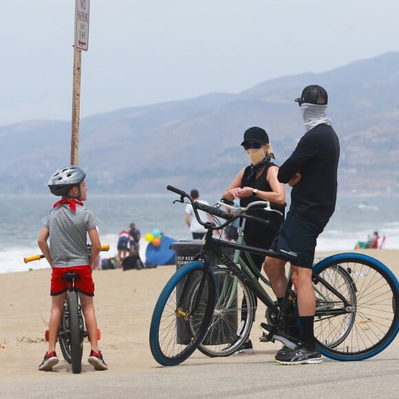 Exclusif - Reese Witherspoon et son mari Jim Toth, munis de masques de protection contre le coronavirus (Covid-19), se promènent à vélo avec leur fils de 7 ans, Tennessee, en bord de mer. Malibu, le 31 mai 2020.