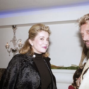 Catherine Deneuve et Johnny Hallyday lors d'une soirée organisée par l'office du tourisme d'Afrique du Sud au restaurant "La Suite", à Paris, le 1 février 2004.