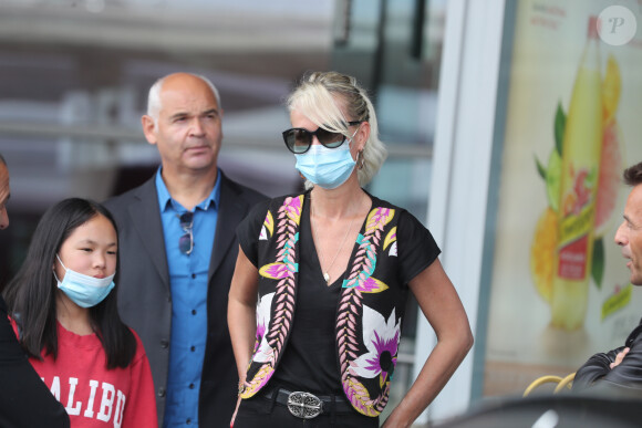 Laeticia Hallyday et ses filles Jade et Joy arrivent, avec des masques de protection contre l'épidémie de coronavirus (Covid-19), à l'aéroport de Paris-Charles-de-Gaulle à Roissy-en-France, France, le 18 juin 2020.