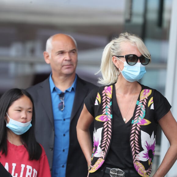 Laeticia Hallyday et ses filles Jade et Joy arrivent, avec des masques de protection contre l'épidémie de coronavirus (Covid-19), à l'aéroport de Paris-Charles-de-Gaulle à Roissy-en-France, France, le 18 juin 2020.