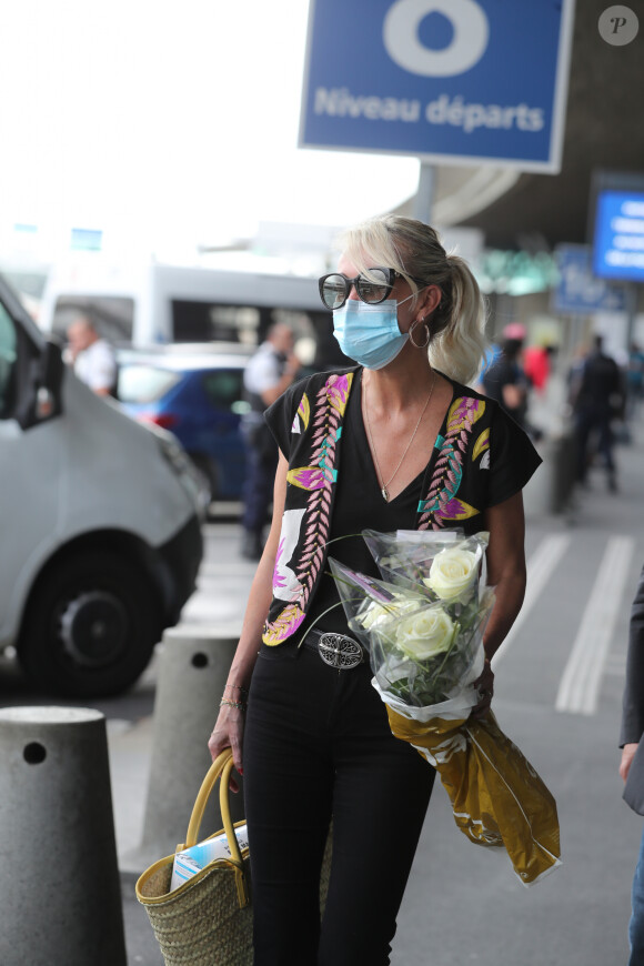Laeticia Hallyday et ses filles Jade et Joy arrivent, avec des masques de protection contre l'épidémie de coronavirus (Covid-19), à l'aéroport de Paris-Charles-de-Gaulle à Roissy-en-France, France, le 18 juin 2020.
