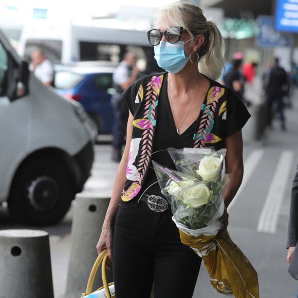 Laeticia Hallyday et ses filles Jade et Joy arrivent, avec des masques de protection contre l'épidémie de coronavirus (Covid-19), à l'aéroport de Paris-Charles-de-Gaulle à Roissy-en-France, France, le 18 juin 2020.