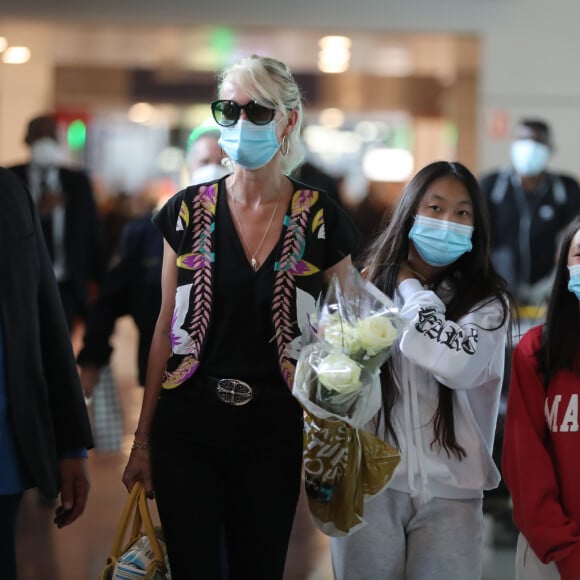 Laeticia Hallyday et ses filles Jade et Joy arrivent, avec des masques de protection contre l'épidémie de coronavirus (Covid-19), à l'aéroport de Paris-Charles-de-Gaulle à Roissy-en-France, France, le 18 juin 2020.