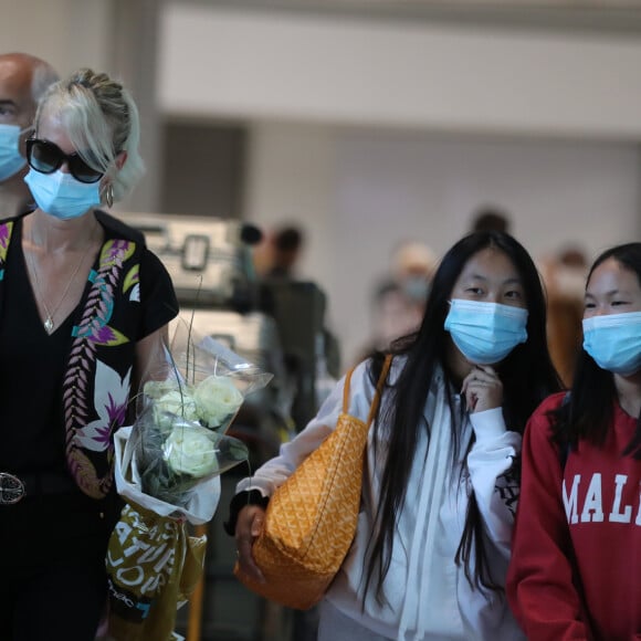 Laeticia Hallyday et ses filles Jade et Joy arrivent, avec des masques de protection contre l'épidémie de coronavirus (Covid-19), à l'aéroport de Paris-Charles-de-Gaulle à Roissy-en-France, France, le 18 juin 2020.