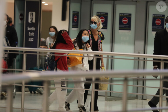 Laeticia Hallyday et ses filles Jade et Joy arrivent, avec des masques de protection contre l'épidémie de coronavirus (Covid-19), à l'aéroport de Paris-Charles-de-Gaulle à Roissy-en-France, France, le 18 juin 2020.