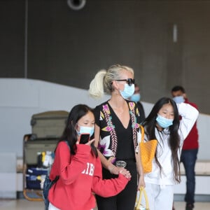 Laeticia Hallyday et ses filles Jade et Joy arrivent, avec des masques de protection contre l'épidémie de coronavirus (Covid-19), à l'aéroport de Paris-Charles-de-Gaulle à Roissy-en-France, France, le 18 juin 2020.