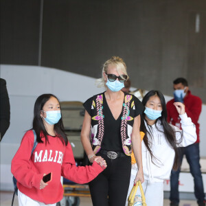 Laeticia Hallyday et ses filles Jade et Joy arrivent, avec des masques de protection contre l'épidémie de coronavirus (Covid-19), à l'aéroport de Paris-Charles-de-Gaulle à Roissy-en-France, France, le 18 juin 2020.