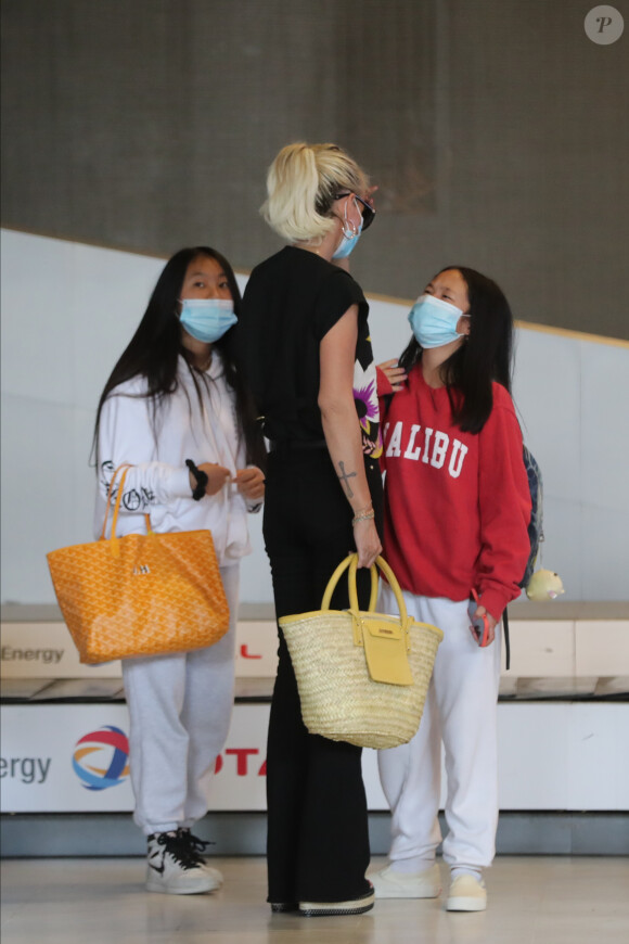 Laeticia Hallyday et ses filles Jade et Joy arrivent, avec des masques de protection contre l'épidémie de coronavirus (Covid-19), à l'aéroport de Paris-Charles-de-Gaulle à Roissy-en-France, France, le 18 juin 2020.