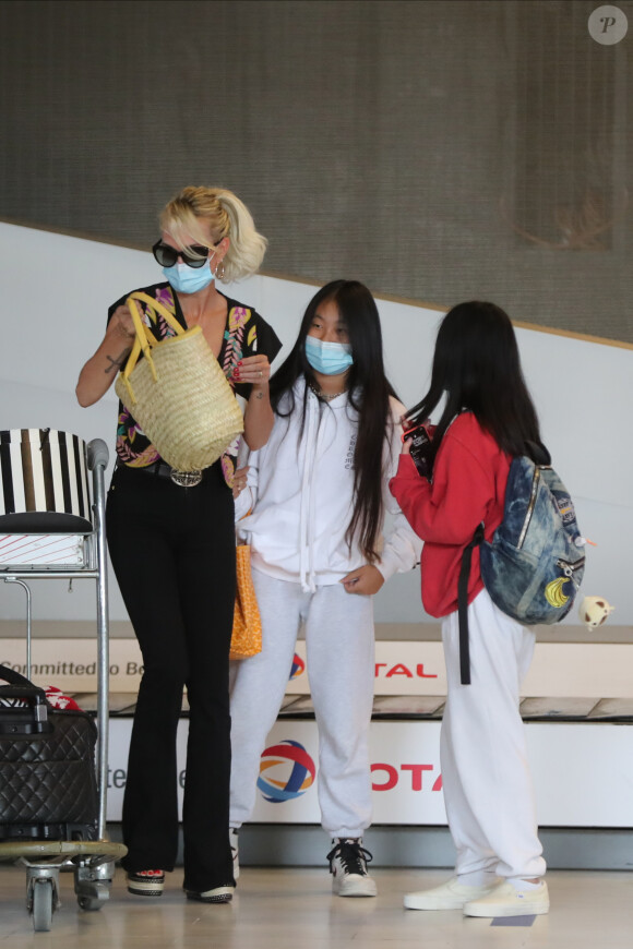 Laeticia Hallyday et ses filles Jade et Joy arrivent, avec des masques de protection contre l'épidémie de coronavirus (Covid-19), à l'aéroport de Paris-Charles-de-Gaulle à Roissy-en-France, France, le 18 juin 2020.