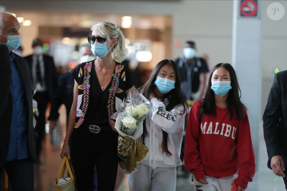 Laeticia Hallyday et ses filles Jade et Joy arrivent, avec des masques de protection contre l'épidémie de coronavirus (Covid-19), à l'aéroport de Paris-Charles-de-Gaulle à Roissy-en-France, France, le 18 juin 2020.