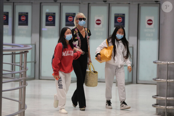 Laeticia Hallyday et ses filles Jade et Joy arrivent, avec des masques de protection contre l'épidémie de coronavirus (Covid-19), à l'aéroport de Paris-Charles-de-Gaulle à Roissy-en-France, France, le 18 juin 2020.