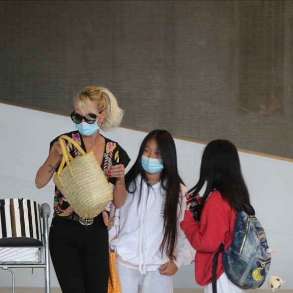 Laeticia Hallyday et ses filles Jade et Joy arrivent, avec des masques de protection contre l'épidémie de coronavirus (Covid-19), à l'aéroport de Paris-Charles-de-Gaulle à Roissy-en-France, France, le 18 juin 2020.