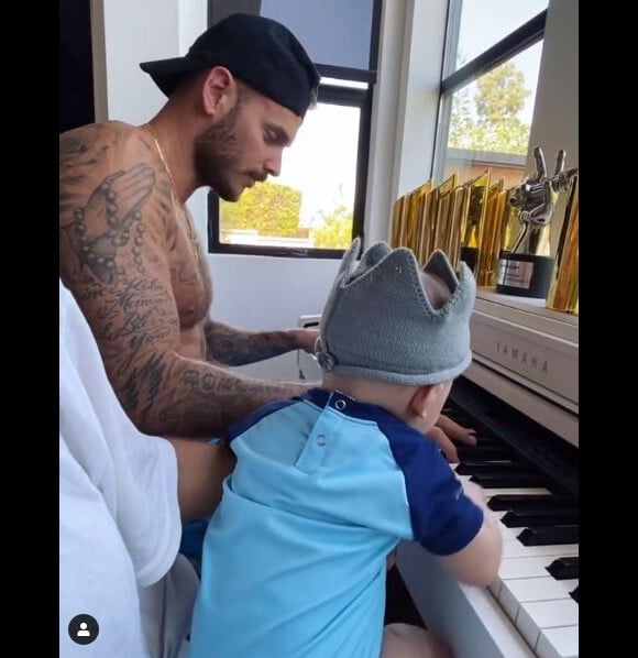 M. Pokora au piano avec son fils Isaiah. Le chanteur français est confiné à Los Angeles avec sa famille. Le 6 mai 2020.
