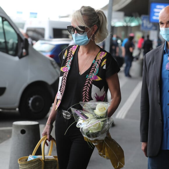 Laeticia Hallyday et ses filles Jade et Joy arrivent, avec des masques de protection contre l'épidémie de coronavirus (Covid-19), à l'aéroport de Paris-Charles-de-Gaulle à Roissy-en-France, France, le 18 juin 2020.