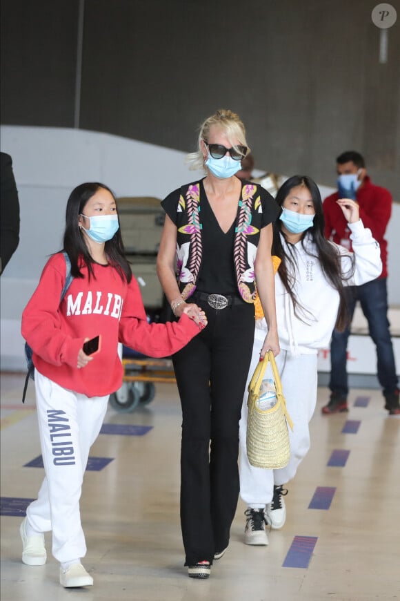 Laeticia Hallyday et ses filles Jade et Joy arrivent, avec des masques de protection contre l'épidémie de coronavirus (Covid-19), à l'aéroport de Paris-Charles-de-Gaulle à Roissy-en-France, France, le 18 juin 2020.