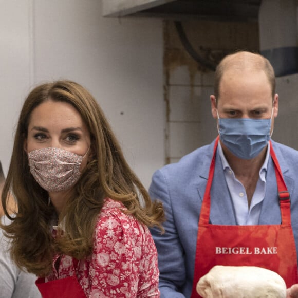 Le prince William, duc de Cambridge, et Kate Middleton, duchesse de Cambridge, font des bagels lors de leur visite à la boulangerie "Beigel Bake Brick Lane" à Londres, le 15 septembre 2020, pendant l'épidémie de coronavirus (Covid-19).