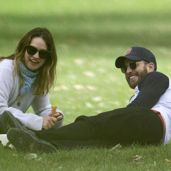 Exclusif - Chris Evans et sa nouvelle compagne Lily James mangent des glaces dans un parc au centre de Londres le 9 juillet 2020. Ils portement des masques pour se déplacer lors de l'épidémie de Coronavirus (COVID-19).