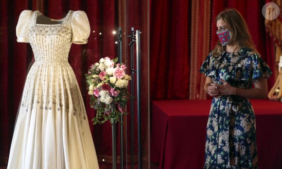 La princesse Beatrice d'York expose sa robe de mariée au château de Windsor, à partir du 24 septembre 2020, comme le veut la tradition accordée aux femmes de la famille royale britannique. Le jour de son mariage, le 17 juillet 2020, la princesse Beatrice d'York portait la robe vintage, garnie de diamants, de Norman Hartnell ayant appartenu à la reine-mère et portée pour la première fois en 1962. Windsor. Le 23 septembre 2020.  Princess Beatrice alongside her wedding dress, talks with Royal Collection Trust curator Caroline de Guitut , ahead of it going on public display at Windsor Castle from september 24, 2020. 