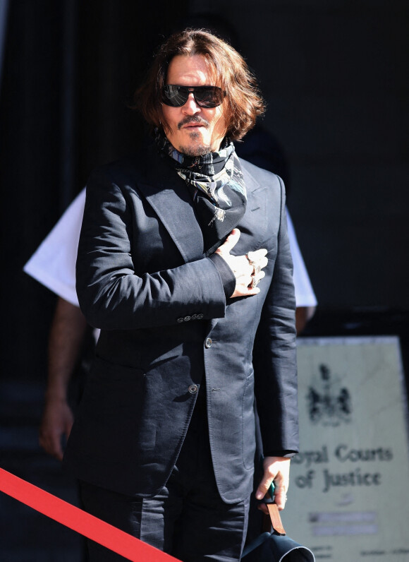 Johnny Depp, souriant, arrive à la cour royale de justice à Londres, pour le procès en diffamation contre le magazine The Sun Newspaper.