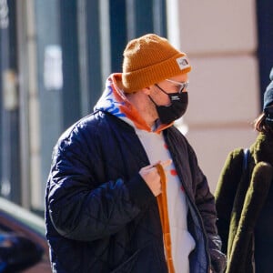 Emily Ratajkowski enceinte et son mari Sebastian Bear-McClard promènent leur chien Colombo dans les rues de New York, le 10 janvier 2021. Emily porte des bottes serpent (python), un jean et un bonnet.