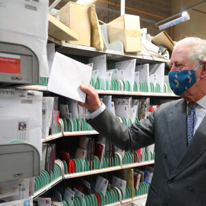 Le prince Charles, prince de Galles, parle au postier Tim Lafford, vêtu d'une tenue de père Noël, lors d'une visite au bureau de livraison de Royal Mail, à Cirencester, pour remercier les postiers du pays qui fournissent, en particulier cette année, un effort supplémentaire jusqu'à Noël. Cirencester le 18 décembre 2020.