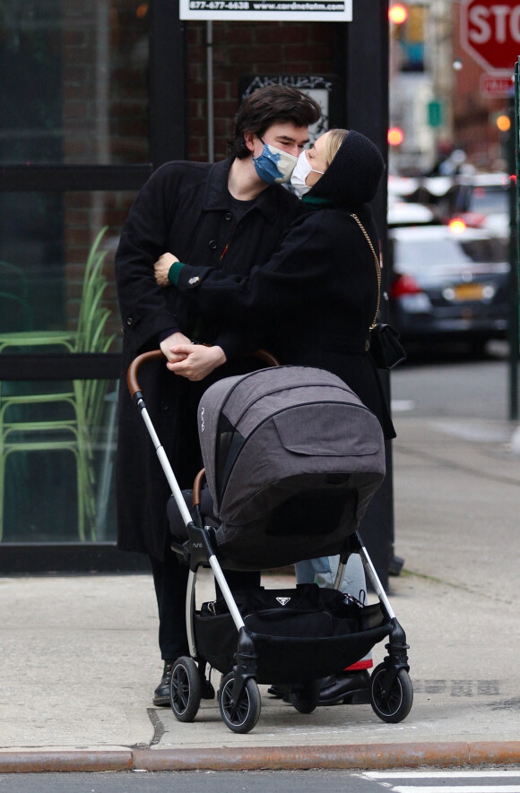 Exclusif - Chloe Sevigny et son compagnon Sinisa Mackovic s'embrassent malgré leur masque de protection contre le Coronavirus (Covid-19) alors qu'ils promènent leur fils en poussette dans les rues de New York, le 17 janvier 2021.