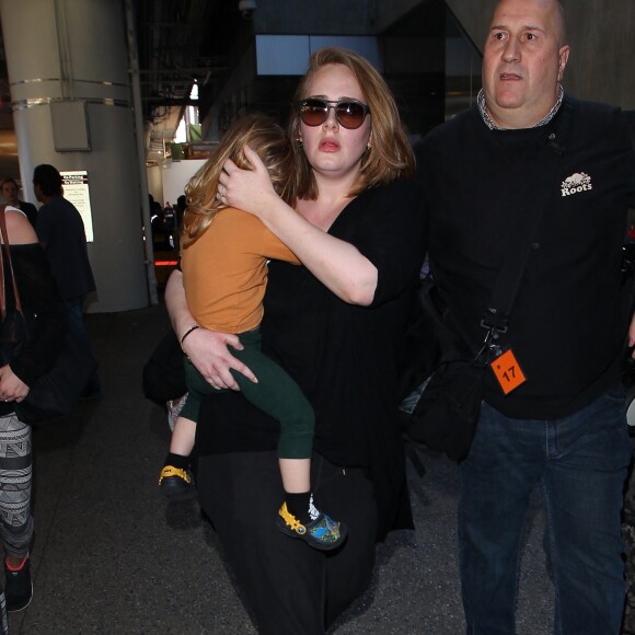 La chanteuse Adele et son fils Angelo Konecki arrivent à l'aéroport LAX de Los Angeles le 3 janvier 2015 entourés de nombreux photographes.