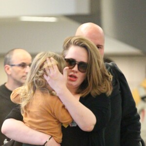 La chanteuse Adele et son fils Angelo Konecki arrivent à l'aéroport LAX de Los Angeles le 3 janvier 2015 entourés de nombreux photographes.