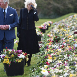 Le prince Charles, prince de Galles et la duchesse de Cornouailles Camila Parker-Bowles passent en revue les hommages au prince Philip dans les jardins de Marlborough House à Londres le 15 avril 2021.